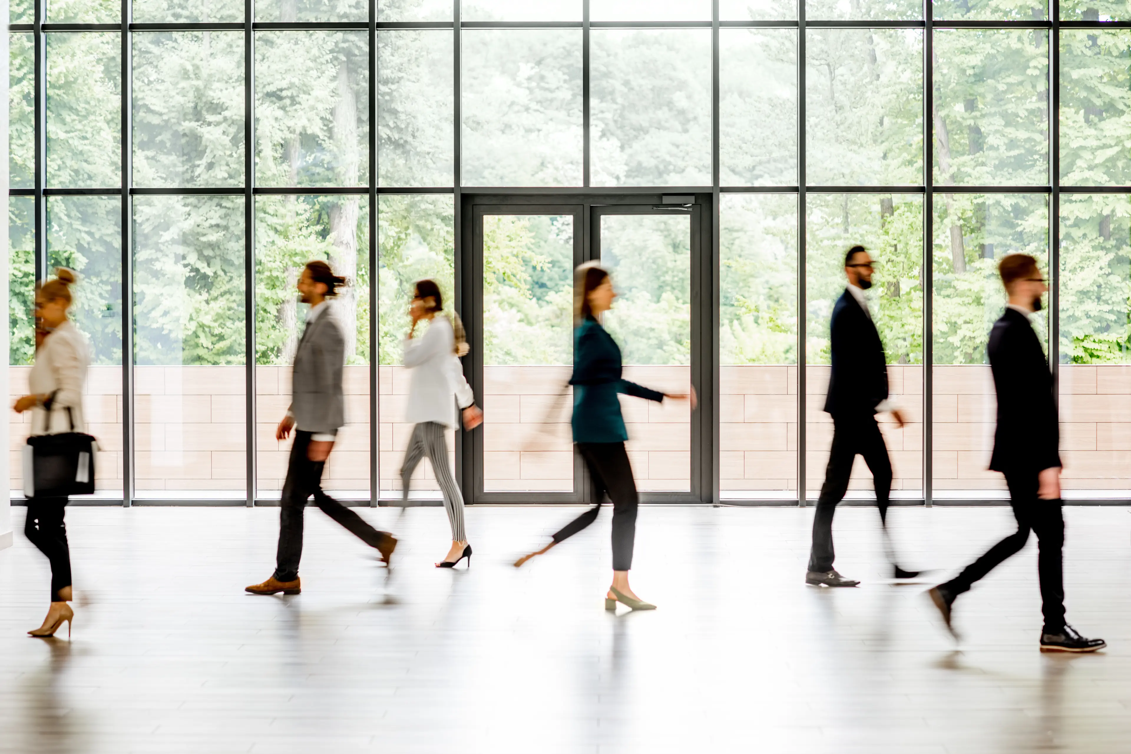 plusieurs personnes qui marche devant l'entrée du bâtiment