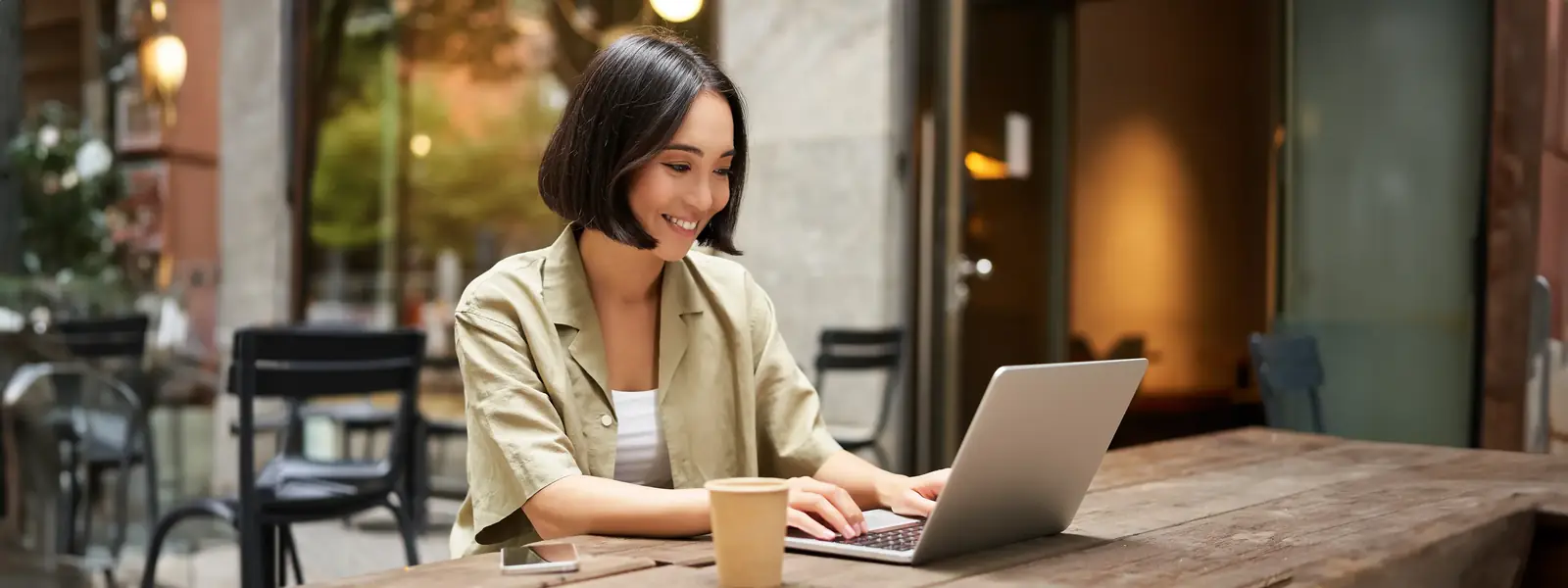Femme travaillant sur ordinateur portable en espace de coworking avec ambiance conviviale