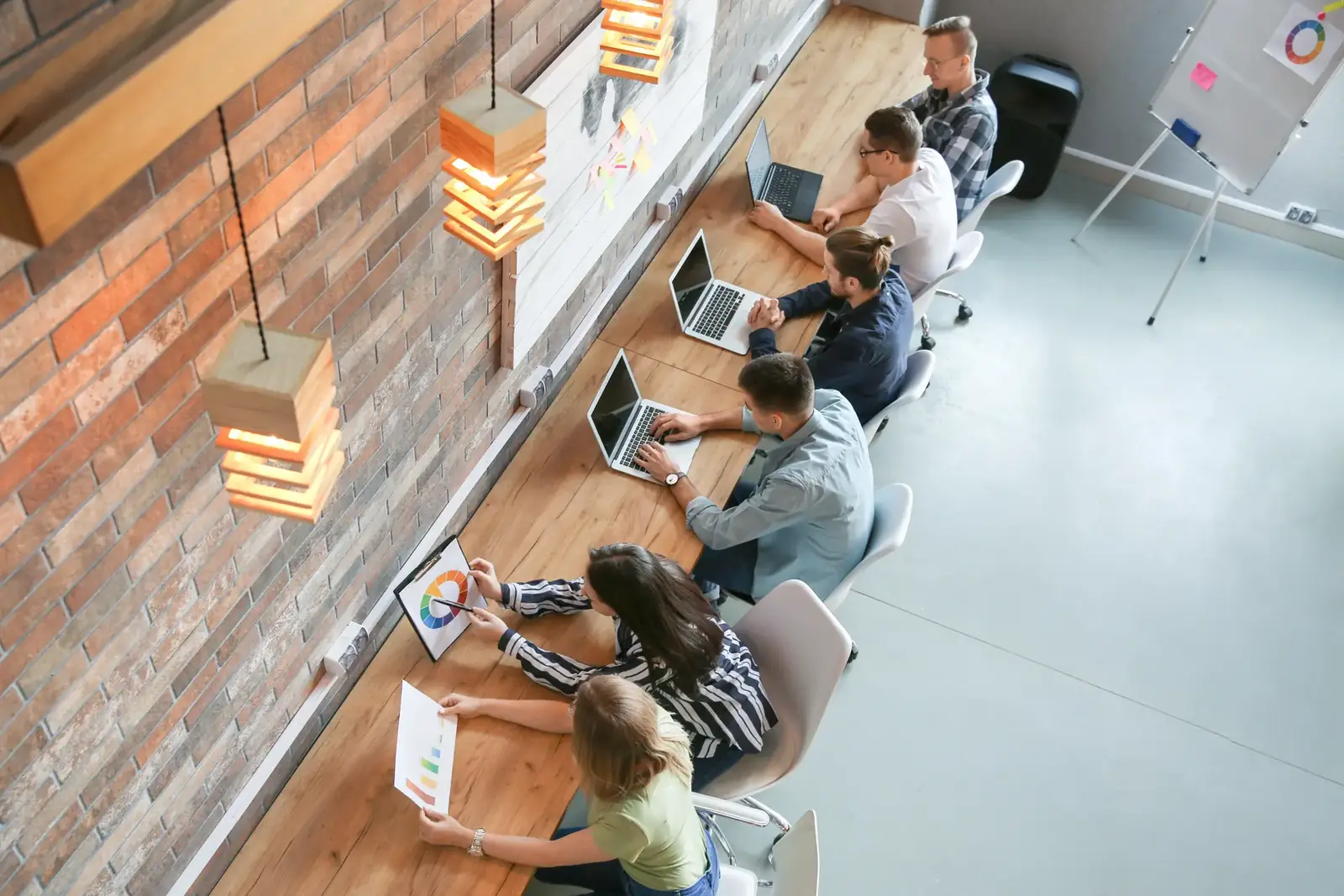 Groupe de personnes travaillant ensemble sur ordinateurs portables dans un espace de coworking moderne